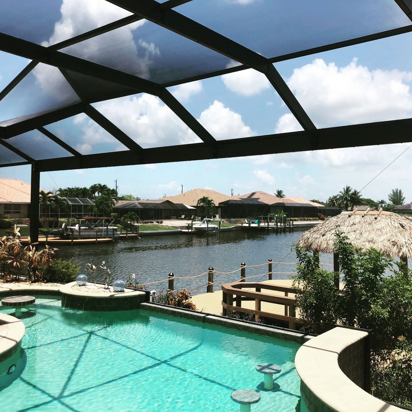 Pool cage screen enclosure with backyard view in Southwest Florida