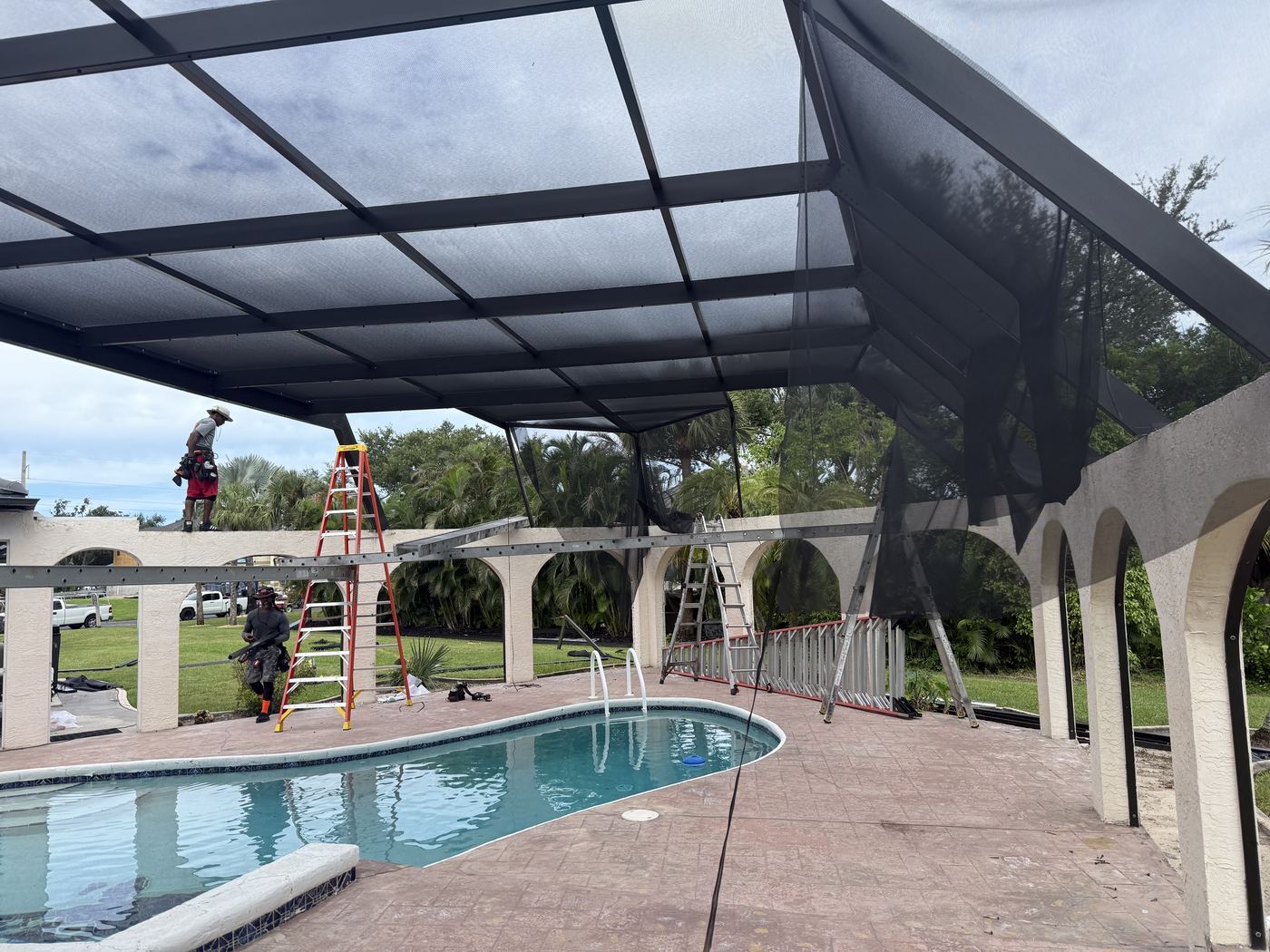 Re-screen installation in progress on a pool enclosure